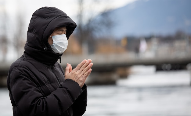 Jovem asiático vestindo uma máscara para evitar germes, fumaça tóxica e poeira