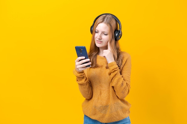 Jovem assistindo videoclipes no telefone em fones de ouvido com fio em casual