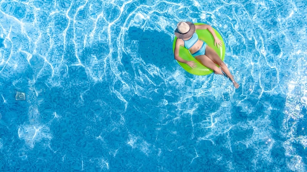 Jovem ativa na piscina vista aérea de cima do adolescente relaxa e nada no anel