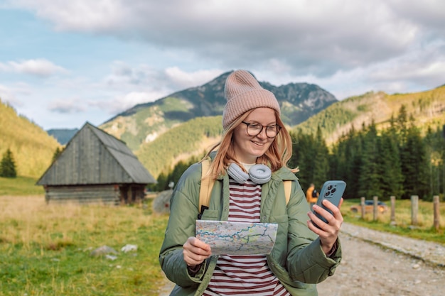 Jovem ativa segurando a leitura de um mapa enquanto faz uma pausa para caminhadas se divertindo e relaxando enquanto s