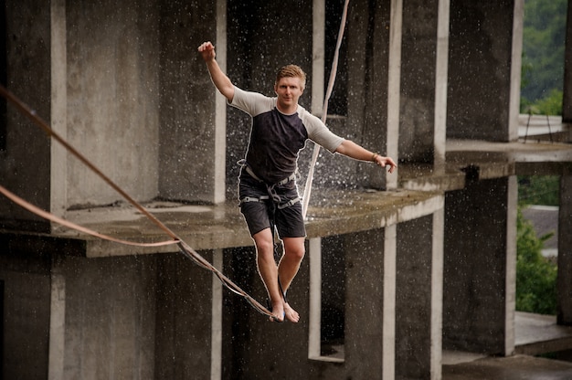 Jovem ativo e corajoso, equilibrando em um slackline