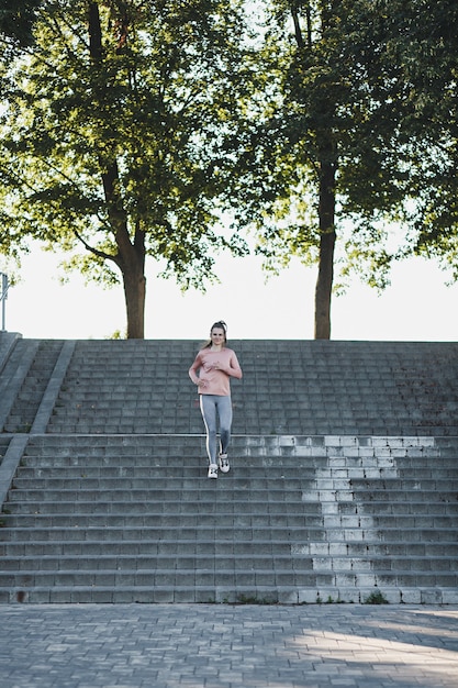 Foto jovem atleta corre escada abaixo em um parque da cidade