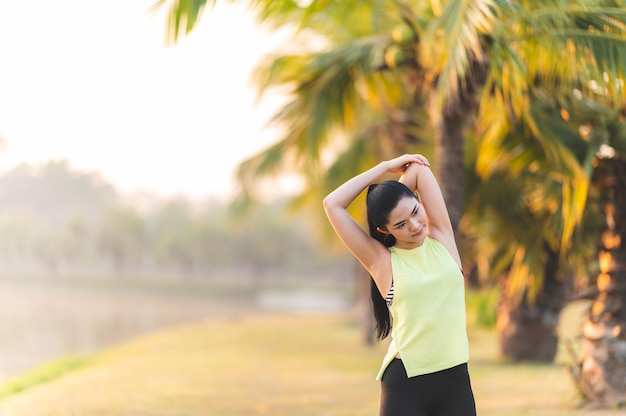 Jovem atleta de fitness se alongando antes de correr no parque