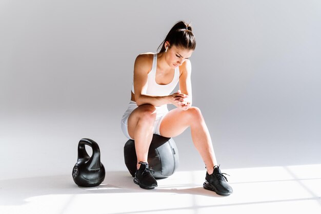 Jovem atleta feminina treinando em uma academia usando equipamentos esportivos