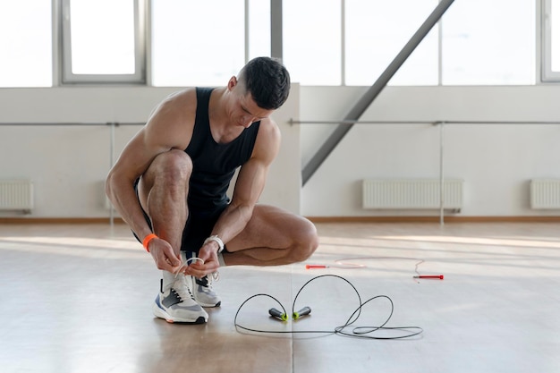 Jovem atleta latino treinando na academia se preparando para realizar exercícios na corda Estilo de vida saudável