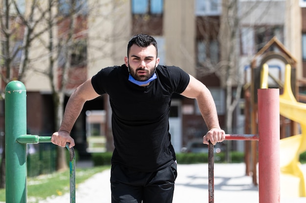 Jovem atleta malhando tríceps em uma academia ao ar livre fazendo exercícios de treino de rua