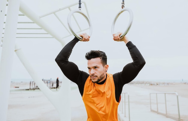 Jovem atleta treinando de manhã na praia na academia