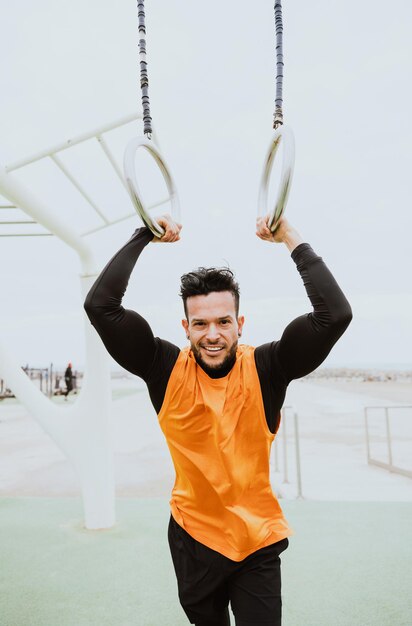 Jovem atleta treinando de manhã na praia na academia