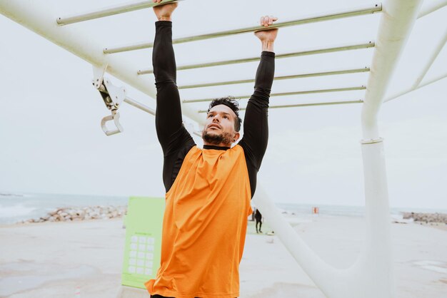 Jovem atleta treinando de manhã na praia na academia