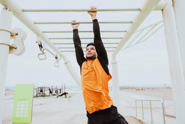 Jovem atleta treinando de manhã na praia na academia