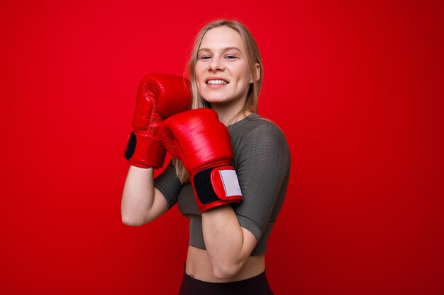 Jovem atlética com luvas de boxe vermelhas em treinamento