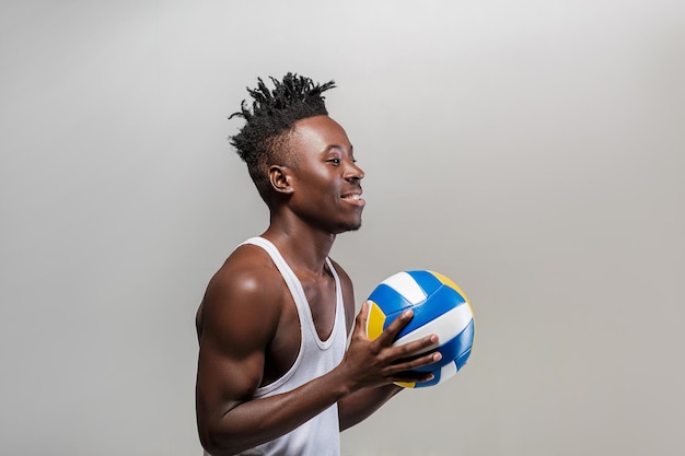 Jovem atlético afro-americano com bola de vôlei