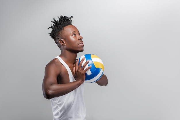 Jovem atlético afro-americano com bola de vôlei