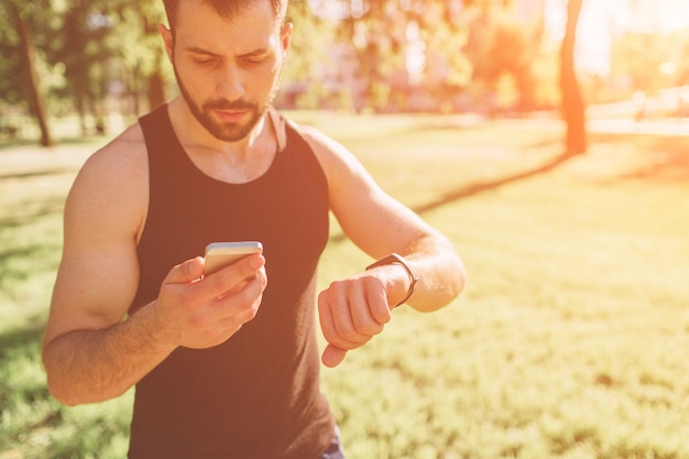 Jovem atlético após o treino. musculoso jovem bonito bebe uma proteína. atraente esportista sem camisa atlética bebendo nutrição esportiva shake do liquidificador.