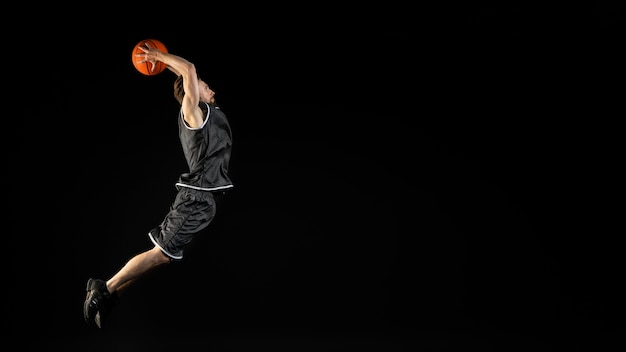 Foto jovem atlético segurando uma bola de basquete