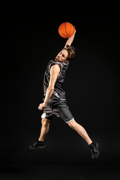 Foto jovem atlético segurando uma bola de basquete