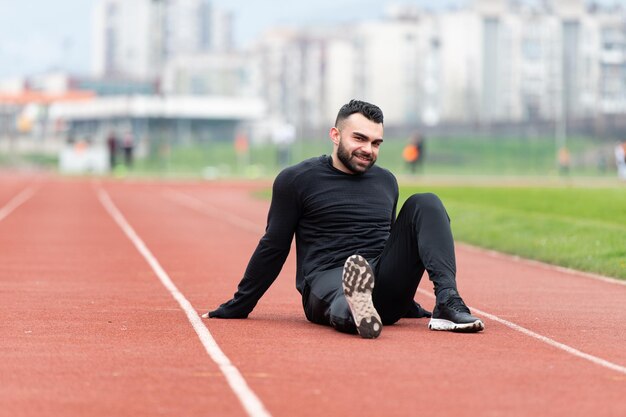 Jovem atraente descansando depois de correr lá fora