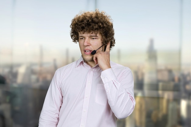 Foto jovem atraente e confiante homem de sucesso falando no microfone falando em negócios corporativos