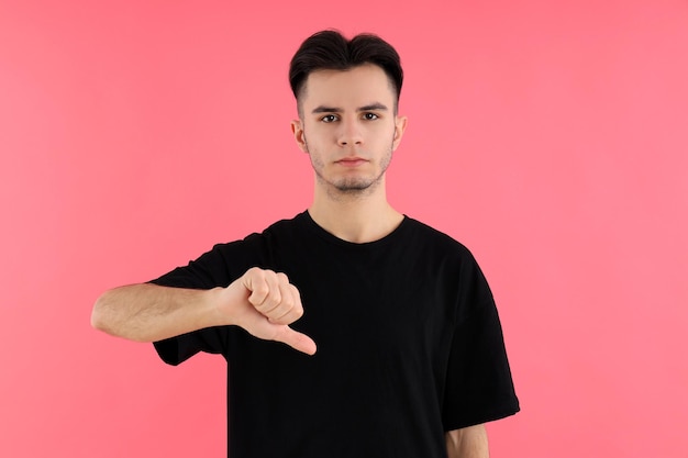 Jovem atraente em t-shirt no fundo rosa