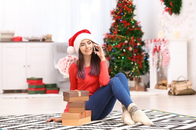 Jovem atraente falando no celular em casa