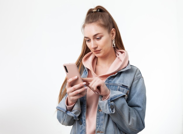 Jovem atraente mulher caucasiana usando smartphone isolado no fundo branco