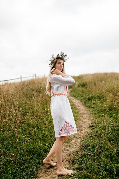 Jovem atraente mulher loira descalça vestido branco