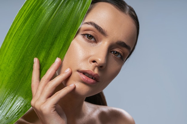 Jovem atraente natural com folha verde