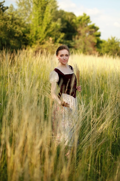 Foto jovem atraente no campo. um modelo em um campo ensolarado.