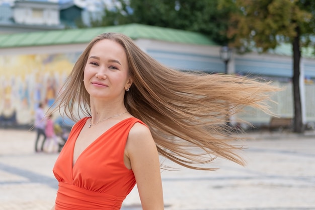 Foto jovem atraente, posando com vestido vermelho na rua