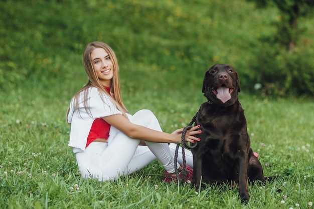 Jovem atraente sentada na grama com sua melhor amiga