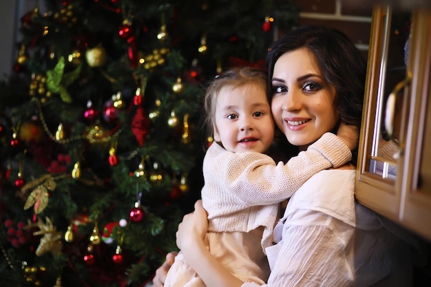 Jovem atraente vestindo pijama quente e uma colcha perto da atmosfera de Natal da árvore de Ano Novo