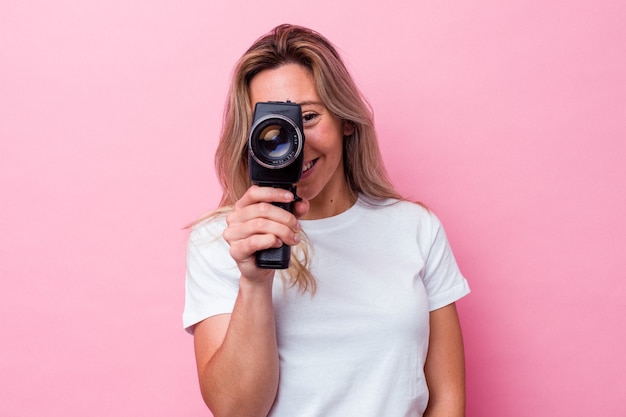 Jovem australiana filmando com uma câmera de vídeo vintage isolada