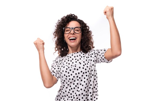 Foto jovem autêntica morena encaracolada mulher magra vestindo camisa de mangas curtas com pontos polka em fundo branco