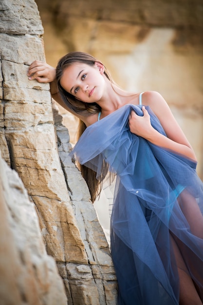 Jovem bailarina de vestido azul inclinada