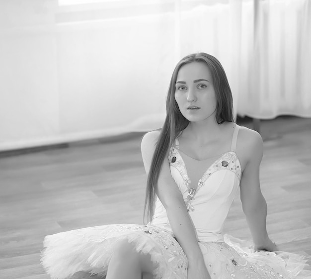 Jovem bailarina em um aquecimento. A bailarina se prepara para se apresentar em estúdio. Uma garota com roupas e sapatos de balé amassa pelo corrimão.