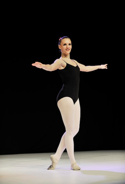 jovem bailarina feliz bailarina executa dança no palco na aula de balé
