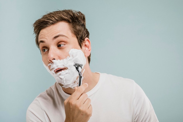 Jovem barbeando a barba