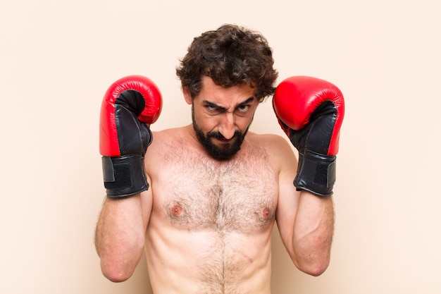 Jovem barbudo com luvas de boxe e conceito de fitness de luta