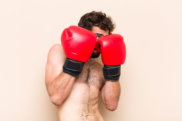 Jovem barbudo com luvas de boxe e conceito de fitness de luta