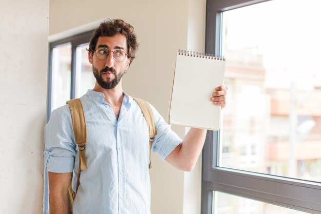 Jovem barbudo com um caderno