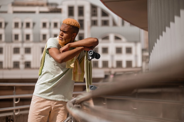 Jovem barbudo de pele escura com um skate