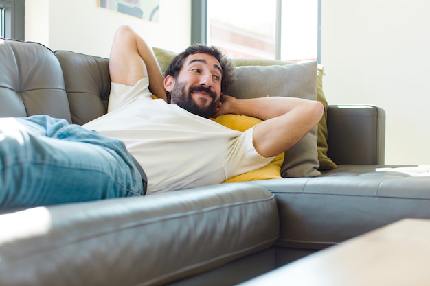 Jovem barbudo descansando em um sofá