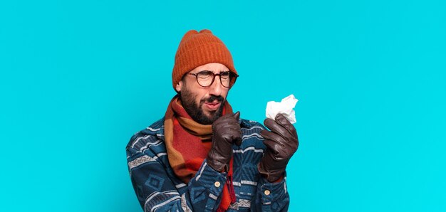 Jovem barbudo e vestindo roupas de inverno. conceito de doença