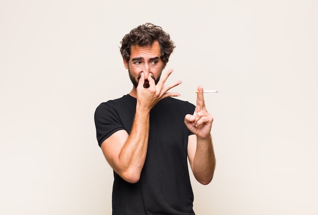 Foto jovem barbudo fumando um cigarro