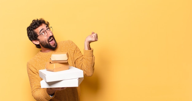Jovem barbudo louco tirando fast food com espaço de cópia