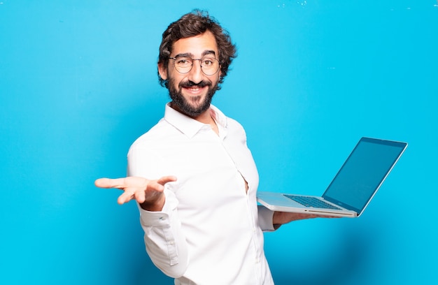 Jovem barbudo segurando um laptop