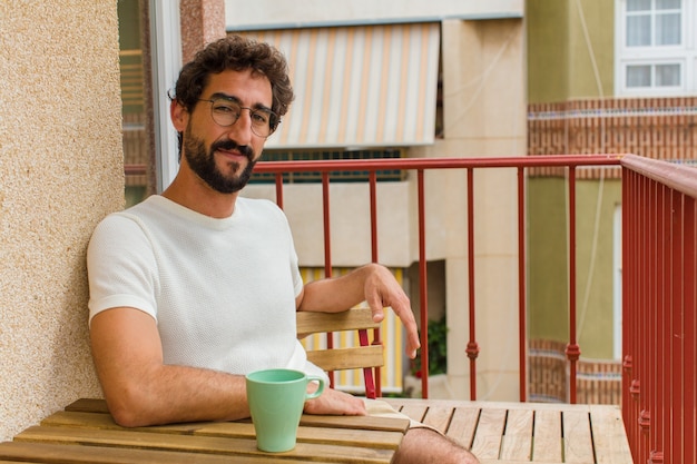 Jovem barbudo tomando um café