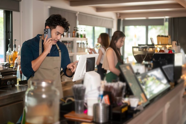 Jovem barista asiático preocupado com o serviço com cliente na cafeteria