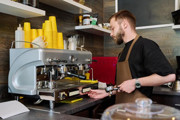 Foto jovem barista preparando café em uma cafeteria