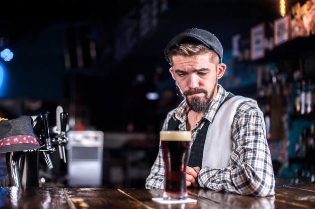 Jovem barman demonstra suas habilidades no balcão atrás do bar